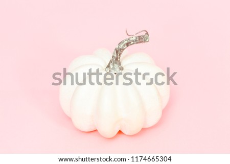 White craft pumpkins of different sizes on a pink background.