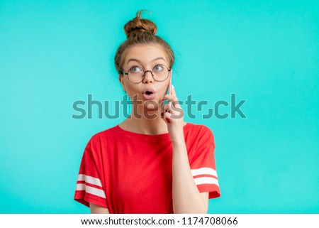 emotional, excited woman is talking on the phone, sharing secrets with friend, discussing last news, gossiping. close up portrait. isolated blue background