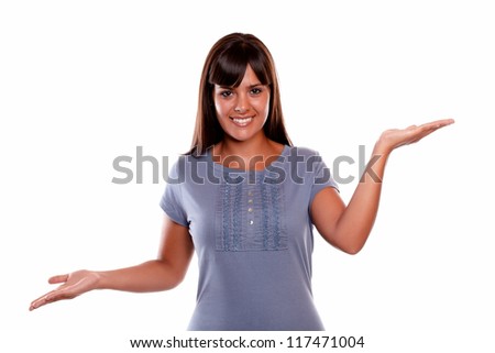 Smiling young woman looking at you with hands up against white background - copyspace