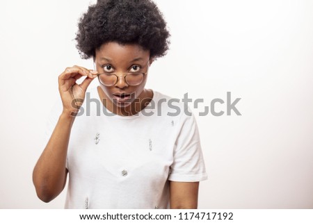 surprised african woman with stunned expression staring at something. close up portrait. copy space. schok , amazement concept