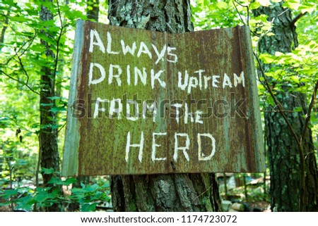 Sign Reading "Always Drink Upstream From The Herd" Colored