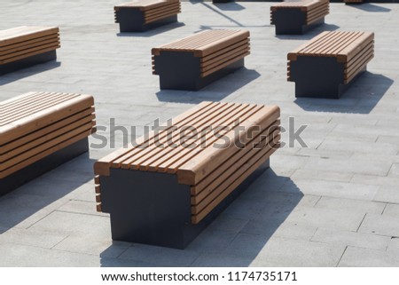 Modern benches in the city square on a sunny day. City improvement, urban planning, public spaces. Royalty-Free Stock Photo #1174735171