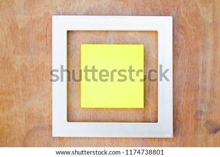 Top view of golden photo frame with paper over wooden background. concept