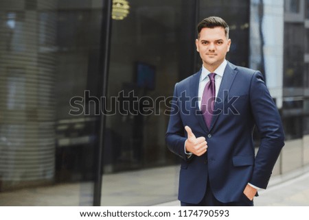 man in a business suit shows his thumb up, a concept of approval