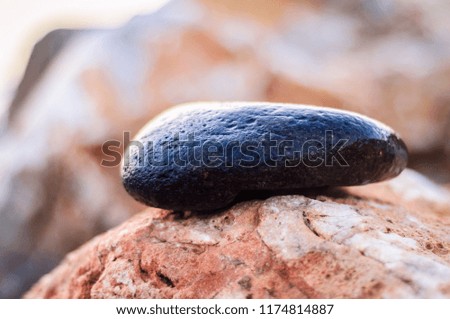 Pebble on magical shoreline environment during sunset with soft focus background 