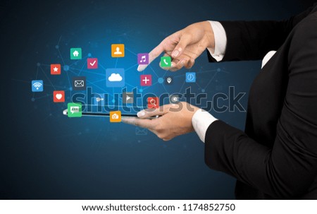 Female hand touching tablet with application icons above