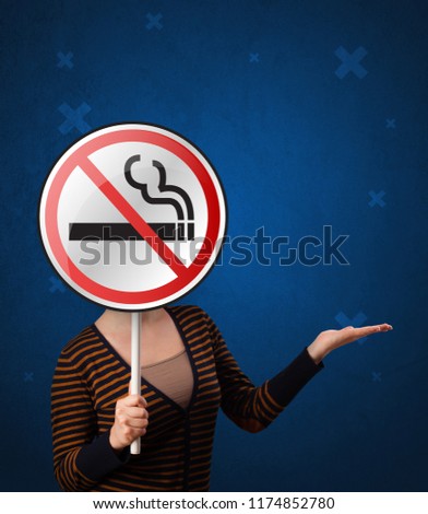 Casual young woman holding round sign with no smoking graphic