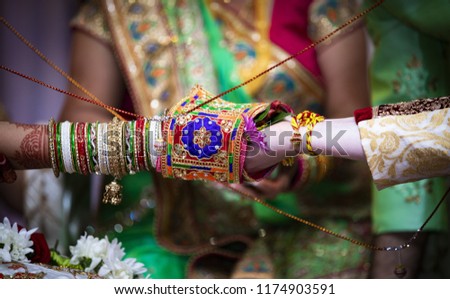 Indian bride and groom holding leaf and performing a rasam.