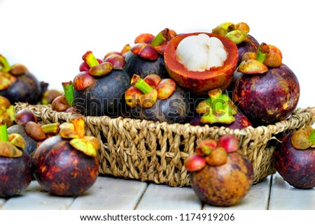 Still life photography of Thai fruit: Mangosteen is queen of fruits. Organic mangosteen is popular fruits, Fruits on seagrass basket. Isolated on white background. Clean food good taste idea concept.
