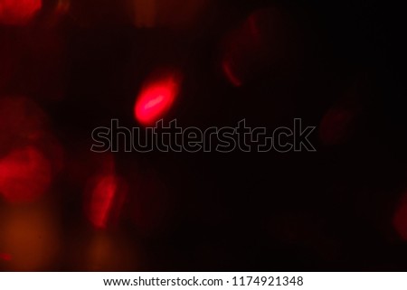 abstract lens flare on black background. red defocused lights. glowing blurred color burst. festive new year backdrop.