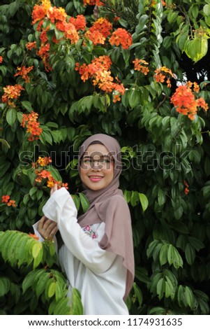 beautiful portrait shoot of young Asian girl at outdoor park in the morning with coco color hijab