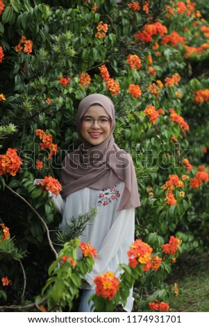 beautiful portrait shoot of young Asian girl at outdoor park in the morning with coco color hijab
