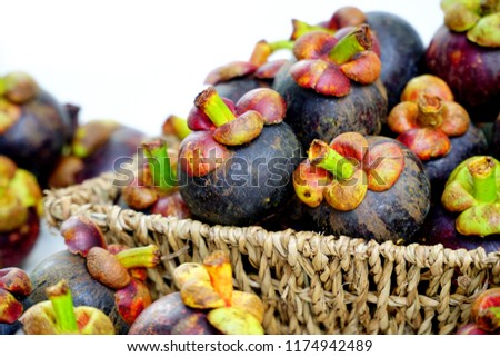 Still life photography of Thai fruit: Mangosteen is queen of fruits. Organic mangosteen is popular fruits, Fruits on seagrass basket. Isolated on white background. Clean food good taste idea concept.