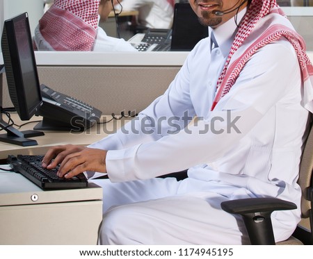 Portrait of a smiling Middle eastern employee with headphones on, in a call center Royalty-Free Stock Photo #1174945195