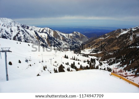 high snowy mountains in cloudy day, mounting skiing resort Shymbulak or Chimbulak, Almaty, Kazakhstan