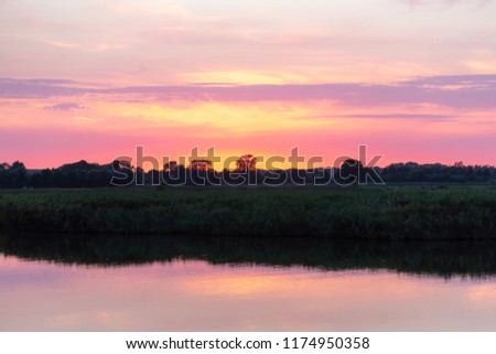 beautiful sunset in pastell colors over smooth and quiet river in greifswald germany