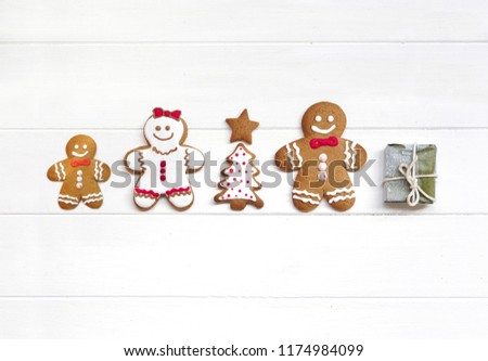 Сreative Christmas composition with chocolate cookie gingerbread men, Christmas tree and gift on white wooden background, flat lay. Christmas and new year concept for family, copy space