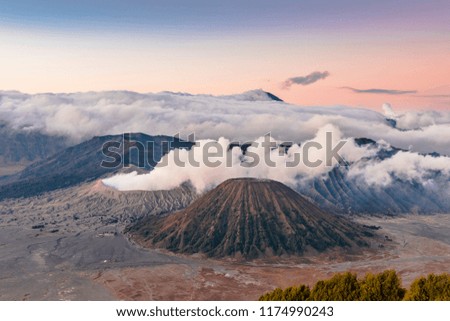 Mount Bromo view in sunrise with Semeru peak background and blue sky misty morning. Taken in 8 September, 2018.