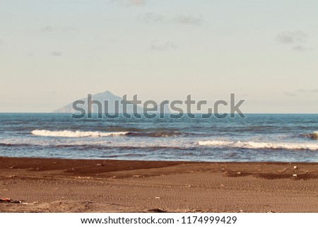 The strong surge and wave sprat at the coastline of Yilan County in Taiwan with the background of the landmark, Guishan Island.