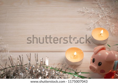Christmas decoration background with pig, snowflakes and tinsel lie on wooden texture. Top view with empty space.