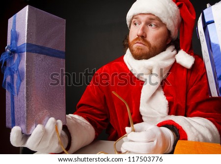 Thoughtful man in santa costume is checking  presents