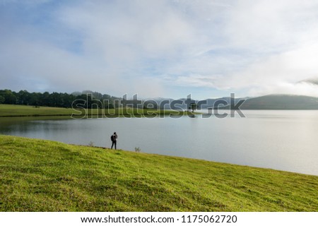 lonely man and lonely tree reflection in the lake at dawn. Picture use for advertising travel, design, tourist