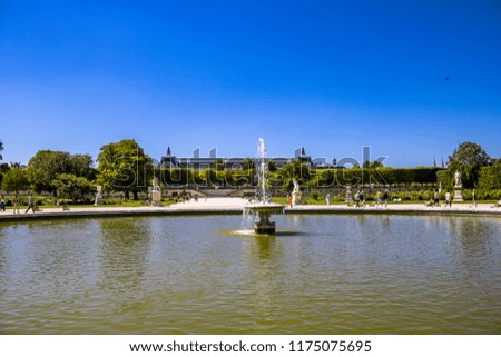 Paris, France. The Fountain at the Jardin des Tuileries (Tuileries Garden) and the roof of the D'Orsay Museum in the background.