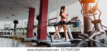 slim beautiful sporty woman running at the treadmill in the gym. Concept of cardio exercises and healthy way of life Royalty-Free Stock Photo #1175095384
