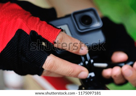 Hands mounting action camera on mountain bike