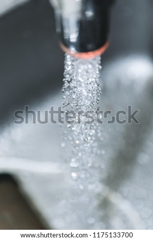 Water flowing down the hole in a kitchen sink. Selective focus.