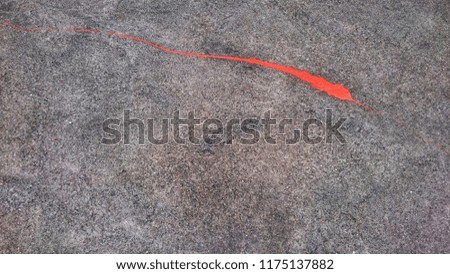 Texture of orange color splash on grey background, orange color drop on the floor. 