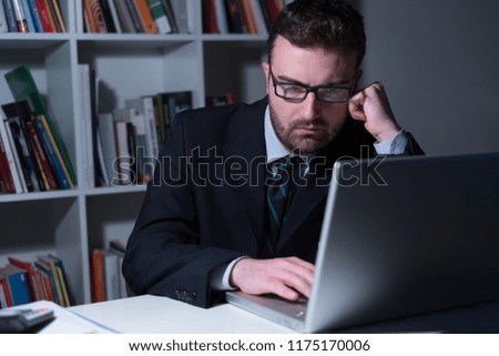 Tired and worried businessman working in the office at night