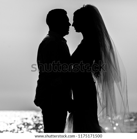 Bride and Groom at Sunset Romantic Married Couple. Silhouette of Happy Young Couple. Woman in a beautiful wedding dress with groom