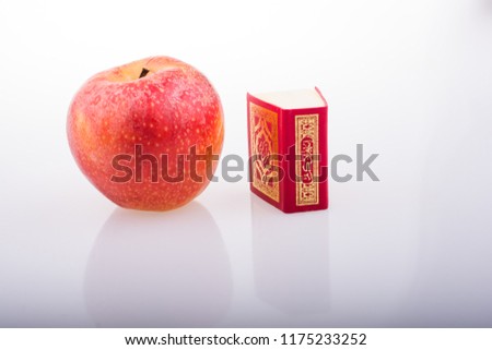 Red apple and  Islamic Holy Book Quran in mini size