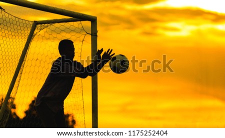 An action sport picture of a kids playing soccer football as a goalkeeper for exercise in community rural area under the sunset.