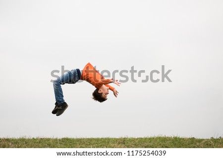 healthy sport little caucasian boy jumping somersault outdoors nature with copyspace Royalty-Free Stock Photo #1175254039