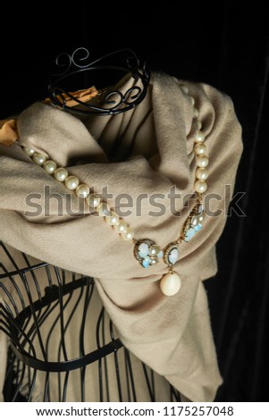 Pearl necklace hanging on a yellow blanket