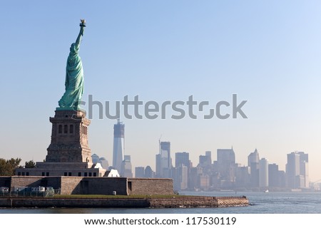 The Statue of Liberty free of tourists and New York City Downtown on sunny early morning