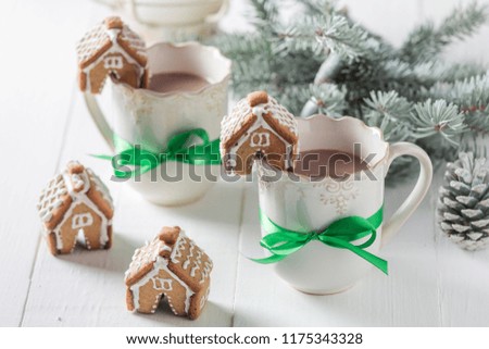 Gingerbread cottages with chocolate for Christmas on white table