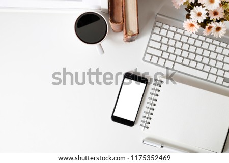 Office desk smartphone mockup, coffee, computer, book and flower on white table with top view.