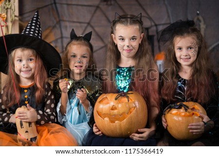 Children in Halloween costumes with pumpkins and sweets
