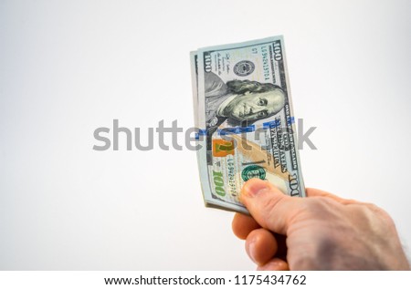 $100 Dollar Bills being offered by hand with white background