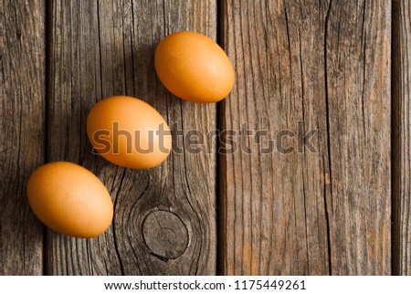 three eggs on weathered wooden table