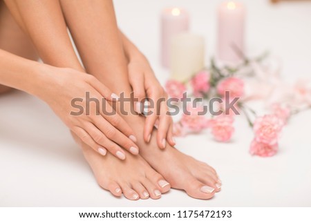 The picture of ideal done manicure and pedicure. Female hands and legs in the spa spot. Royalty-Free Stock Photo #1175472193