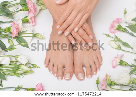 The picture of ideal done manicure and pedicure. Female hands and legs in the spa spot.
