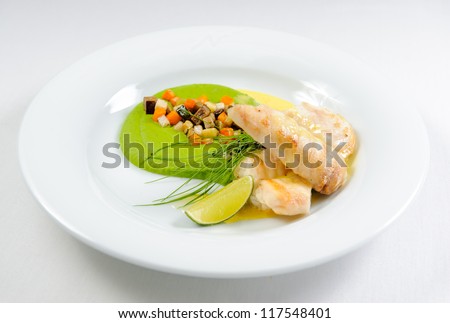 Fish fillet with sauce and vegetables on a plate