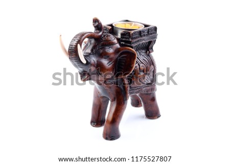 Brown Gold Black elephant made of resin like wooden carving with candle holder with white ivory. Stand on white background, Isolated, Art Model Thai Crafts, For decoration Like in the spa. Engraved pa
