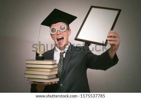 Graduate student holding in hands a diploma certificate and golden medal award isolated on gray background. Education concept.