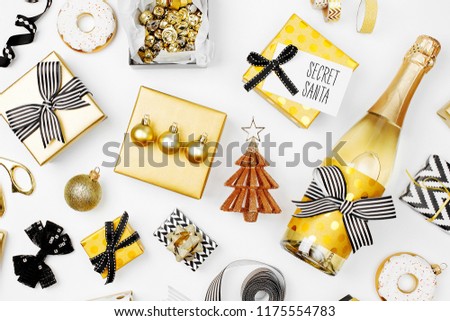 Flat Lay Christmas or Party Background with Gift boxs, Champagne bottle, Bows, Decorations and Wrapping Paper in Gold and Black colors. Flat lay, top view
