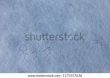 Painted by child three primitive little men holding hands. Picture on the snow. Happy winter season.